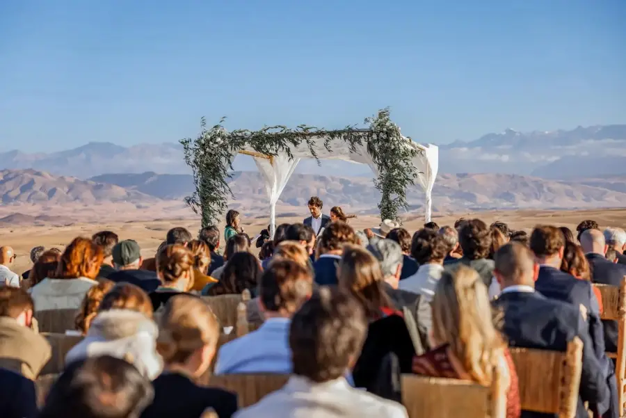 Desert wedding ceremony under a floral canopy with Atlas Mountains backdrop - Agafay wedding Marrakech