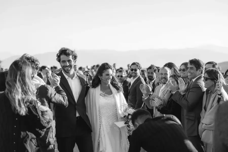Black and white recessional as guests applaud the newlyweds in the desert - Marrakech wedding photography